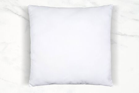 A soft white throw pillow chilling atop a luxurious white marbleの写真素材