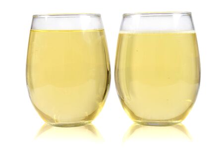 A pair of no stem wineglasses filled with sparkling white wine on a whiteの写真素材