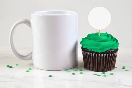 Coffee Cup chilling next to a green frosted chocolate cupcake.の写真素材