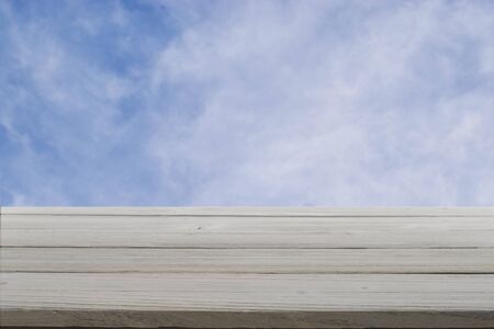 Rustic gray wood against a cloudy blue sky.の写真素材