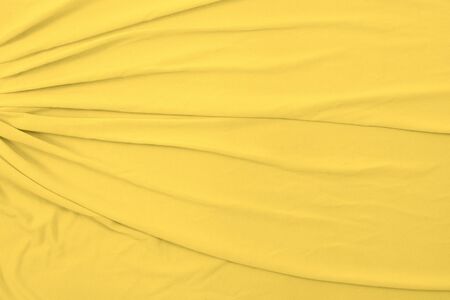 Overhead view of a cheerful light yellow fabric background. Plenty of space for copy.の写真素材