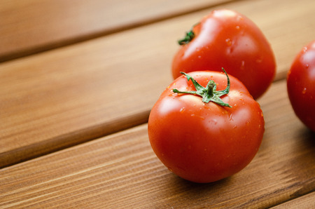 fresh red tomatoes on a wooden tableの写真素材