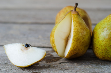 sliced ripe pears on a wooden table with knifeの写真素材