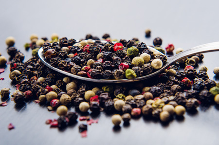 mix of four peppers spoon on a wooden tableの写真素材