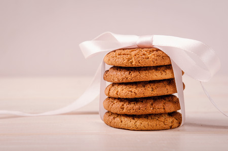 stack of oatmeal cookies tied with a pink ribbon as a giftの写真素材
