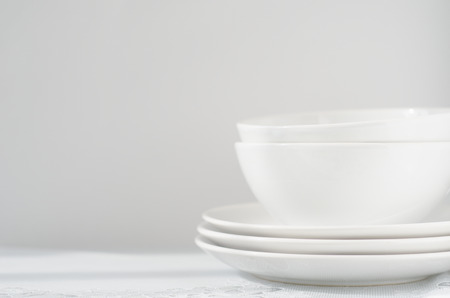 white plates and bowls on light tableの写真素材