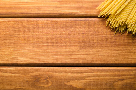a bunch of pasta on a brown wooden  tableの写真素材