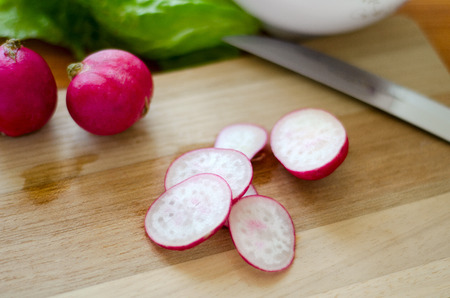 sliced fresh radish close on a wooden cutting boardの写真素材