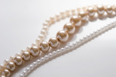 three strings of pearls on white background fashion jewelryの写真素材