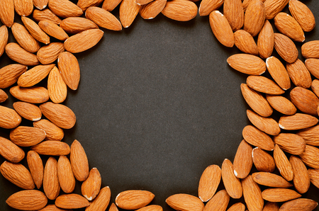 Frame of nuts, almonds. Black background, copy space.の写真素材