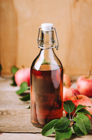 Apple vinegar on wooden table with apples. Country style.の写真素材