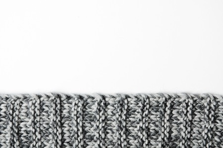 The edge of a gray knitted plaid on white background. Background, copy space.の写真素材