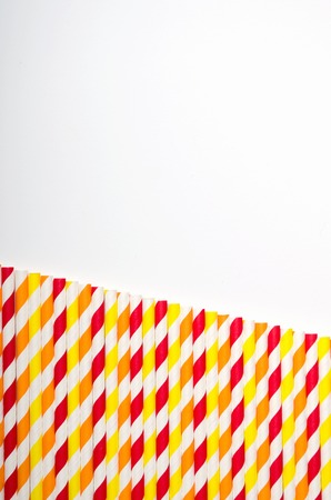 Multicolored juice straw in row on white background. copy space, top viewの写真素材