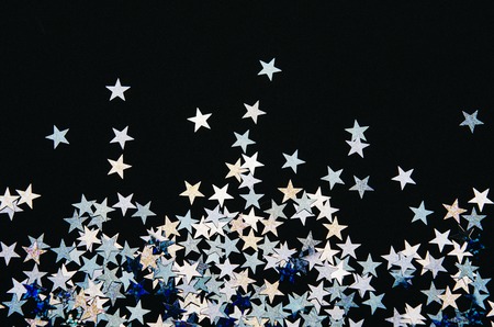 Shiny stars of foil on black background. Festive confetti.の写真素材