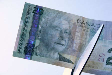 Cutting Costs - Cutting a Canadian twenty dollar bill with sissorsの写真素材