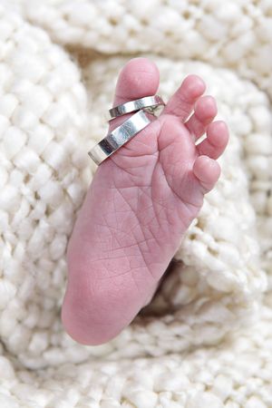 babies foot taken closeup with two ringsの写真素材