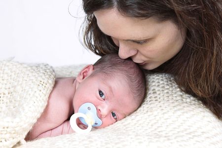 Mom kissing Newborn Baby taken closeup