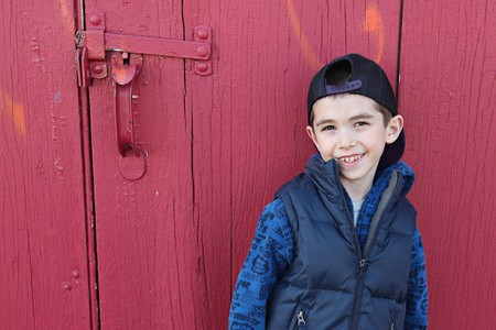 Young child hanging out near a grungy wall の写真素材