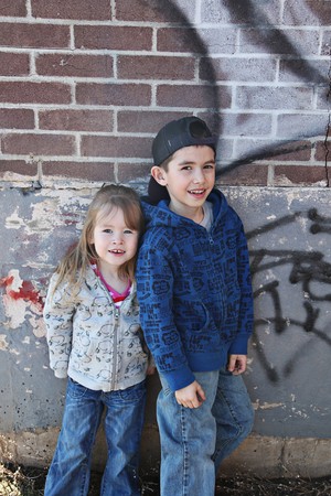 Young children hanging out near a grungy wall の写真素材
