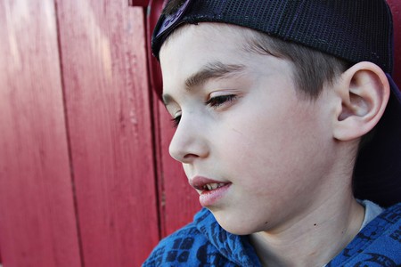 Young child hanging out near a grungy wall の写真素材