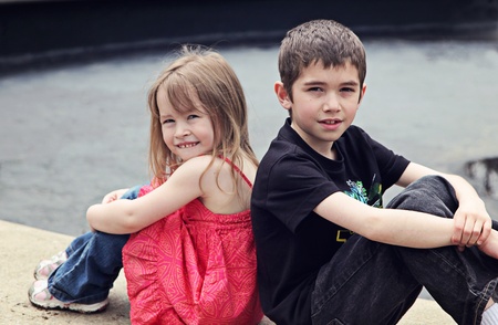 Boy and Girl posing on stone outside in springの写真素材