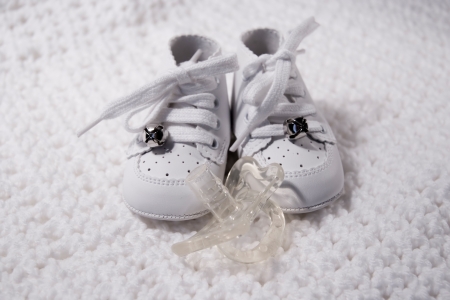 Pair of Babies first shoes with pacifierの写真素材