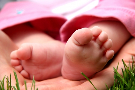 Baby Girl little toes in mother handsの写真素材