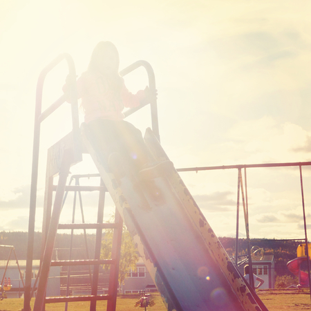 kid riding on slide with vintage effectの写真素材