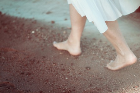 Young woman in white dress walking alone on the beach blured photo in vintage retro style bluredの素材 [FY31056858214]