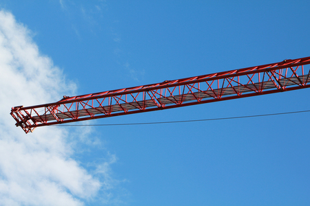 Construction crane of red colour with blue skyの写真素材