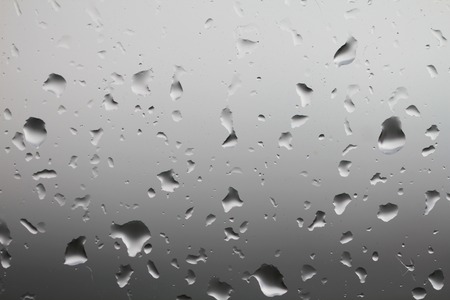 Rain drops on window glass. Clean water drops on defocused view window glass.の写真素材