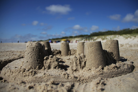 Sand castle on the beach with blue sky backgroundの写真素材