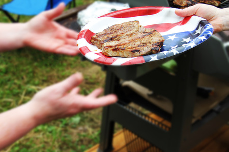 Beef steak on plastic plate with american flag close up photoの写真素材