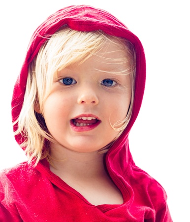 Close-up portrait of a cute young boy in red at the beach isolated on white の写真素材