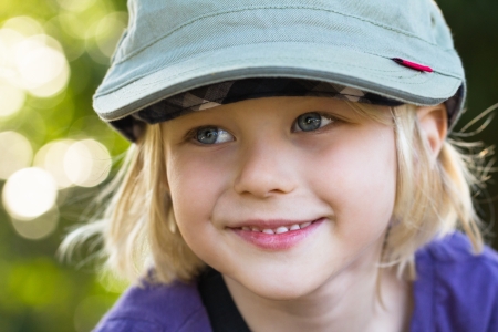 Outdoor portrait of a handsome and happy boy wearing a hatの写真素材