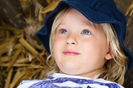 Cute daydreaming child lying down outsideの写真素材
