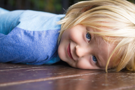 Cute, smiling child lying down looking to camera