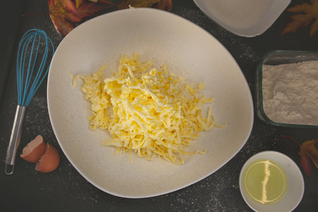 Grated butter mixed into flour with eggs, oil and autumn leaves around - cozy homemade baking...