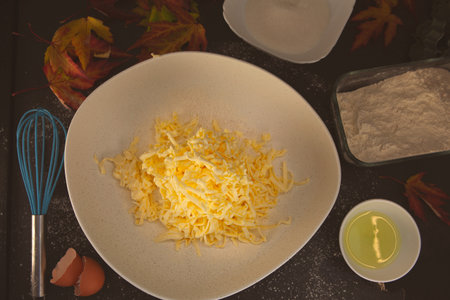 Grated butter mixed into flour with eggs, oil and autumn leaves around - cozy homemade baking...