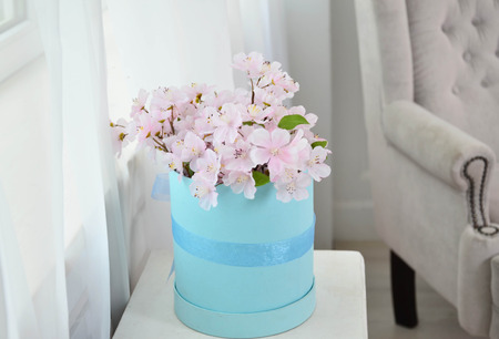 Pink beautiful flowers in a blue box on a white background