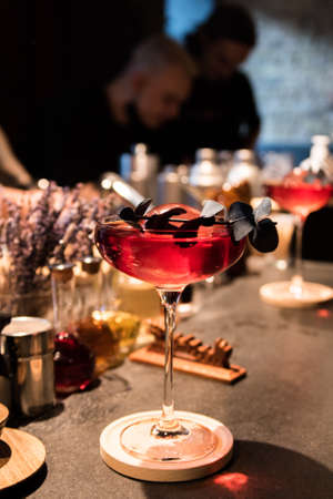 Red cocktail in a high glass with ice on the background of the barの写真素材