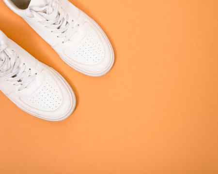 White leather shoes on a beige background. White sneakers with white laces. New shoes. Horizontal imageの写真素材