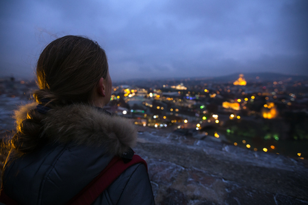 The girl looking at Night Tbilisi. Georgiaの写真素材