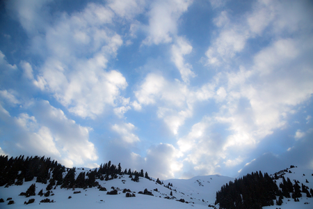 blue sky background with white clouds under the mountainの写真素材