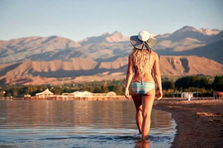 A woman resting on Lake Issyk-Kul at sunriseの写真素材