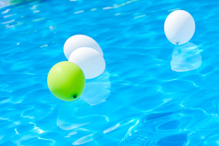 The balloons swimming in the summer pool. Poolside party. The balloons on water.の写真素材