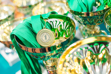 Gold medal in a trophy cup. Victorious cups in sports meets. Cups of winners. Trophy cups.の写真素材