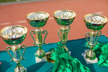 Victorious cups in sports meets. Cups of winners. Trophy cups close up.の写真素材