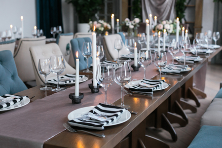 Wedding decor. Wedding interior. Festive decor. Table decor. Table layout. Restaurant interior. The burning candles on a table.の写真素材