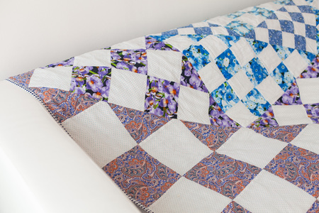 Patchwork quilt. Part of patchwork quilt as background. Color blanket. Handmade. White interior....